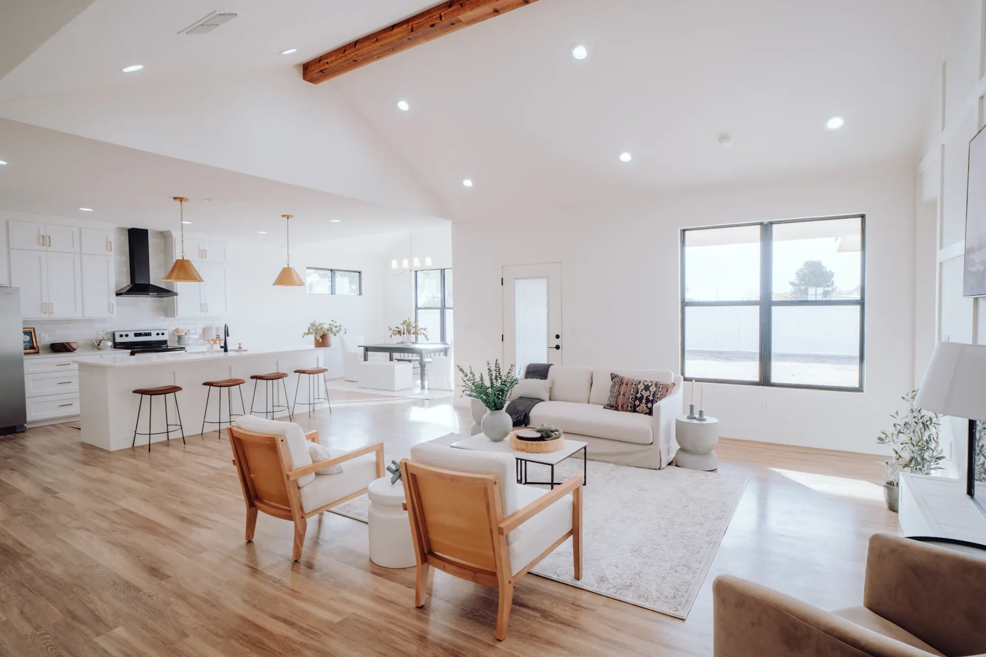 A bright, open-plan living room with white sofa, vaulted ceiling and abundant natural light, professionally cleaned by Wonderful Laura Cleaning